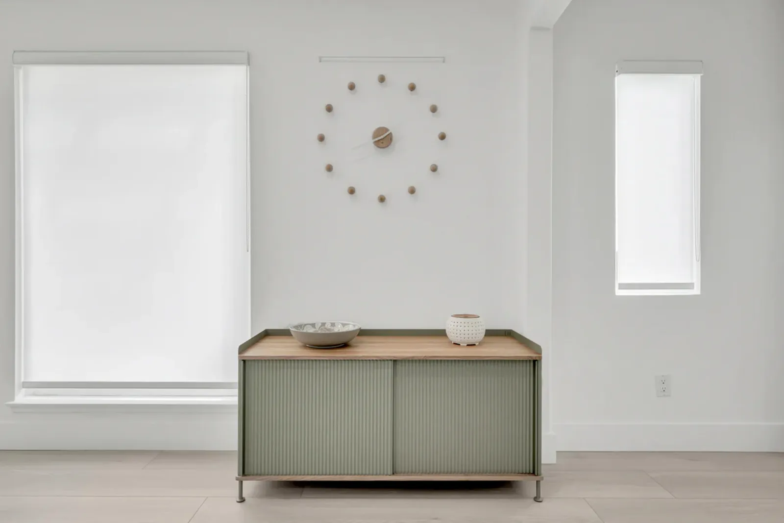Finished living-area wall with a credenza and wall clock from a PMK Development project in Fullerton