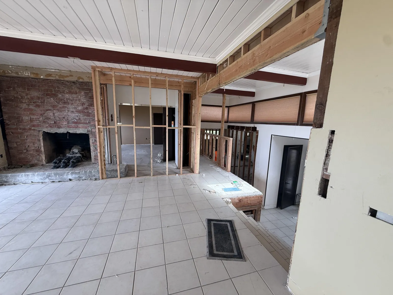 Living room with brick fireplace and open stud framing at the Cartier remodel in Rancho Palos Verdes.
