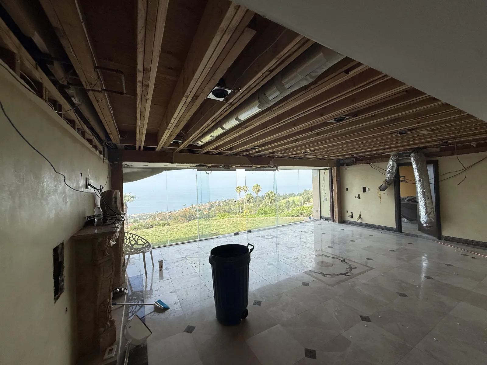 Great room opened to the ceiling joists, with glass walls facing the ocean, at the Cartier remodel in Rancho Palos Verdes.