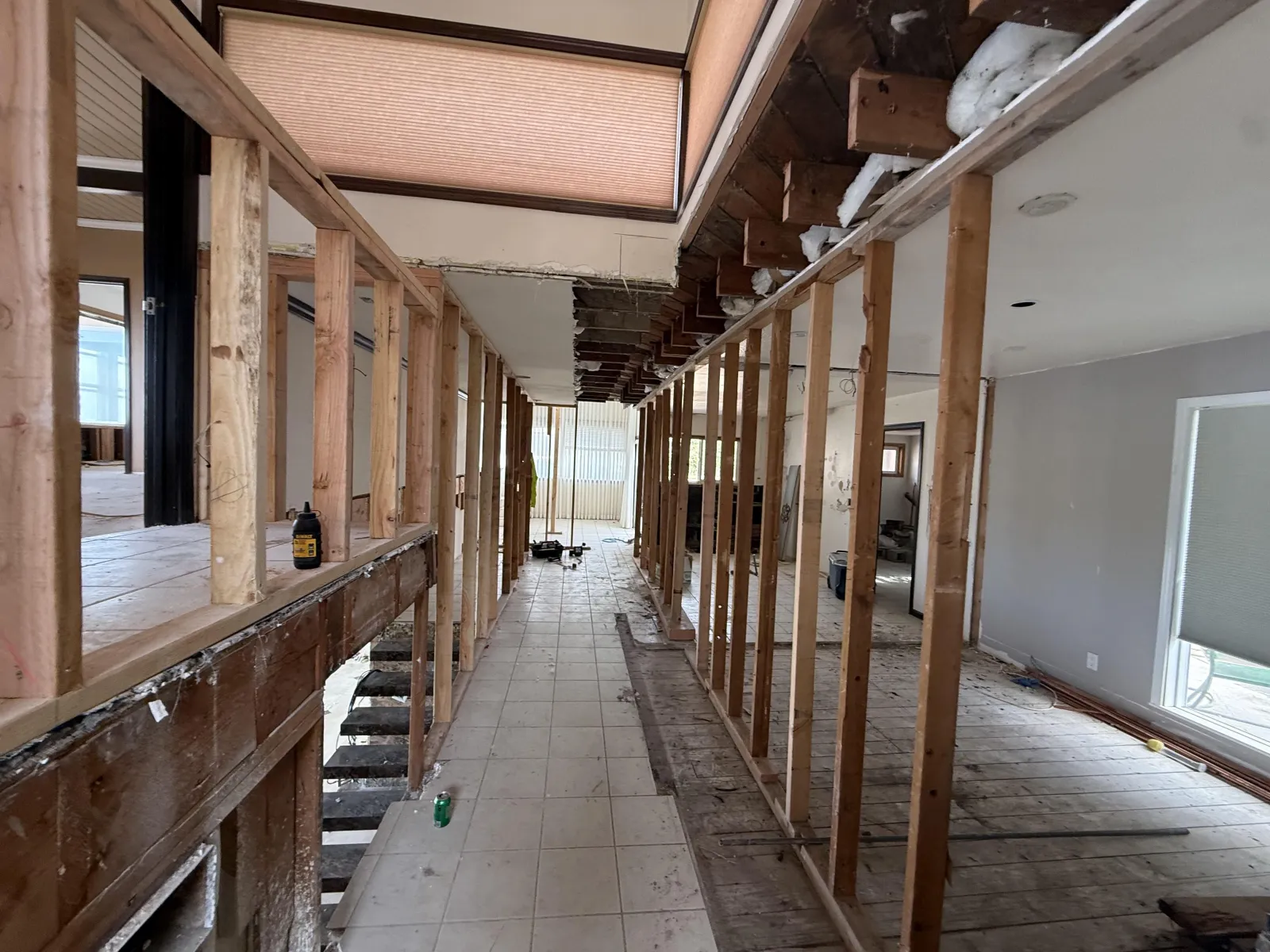 Long hallway with exposed stud walls under a skylight at the Cartier remodel in Rancho Palos Verdes.