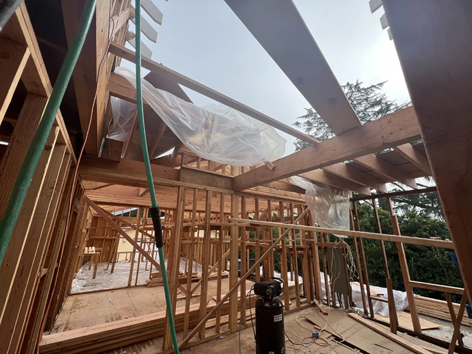 Chevy Chase new construction, roof framing under weather protection, La Cañada Flintridge