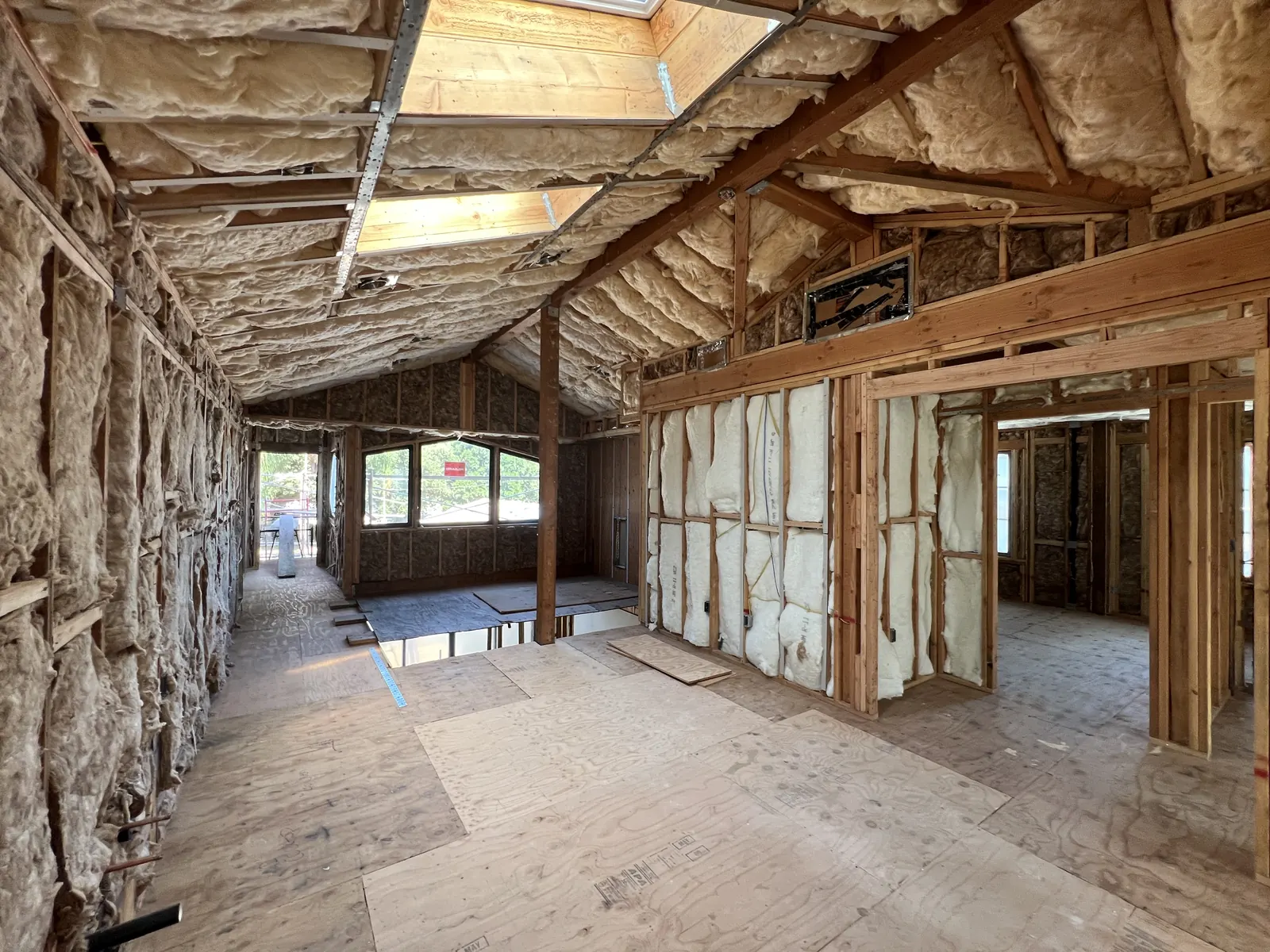 Wall and roof insulation installed throughout the interior, with skylight wells framed, at PMK's new-construction project in La Cañada Flintridge.