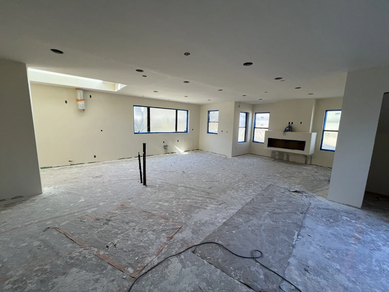 Finished drywall in the main living space with the linear fireplace opening framed in, at PMK's new-construction home in La Cañada Flintridge.