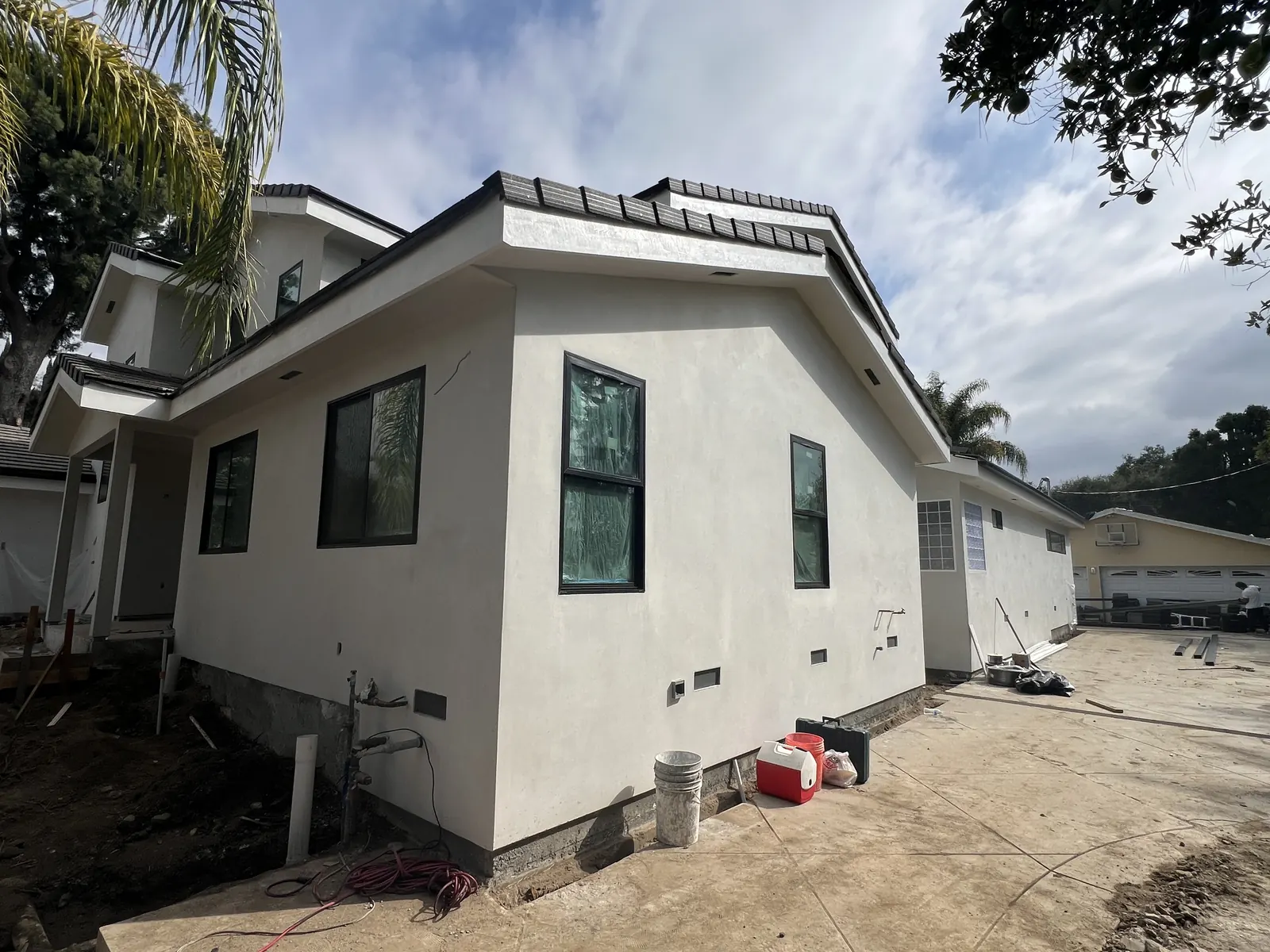 Smooth-coat stucco exterior with black-framed windows and new tile roofline at PMK Development's new-construction project in La Cañada Flintridge.