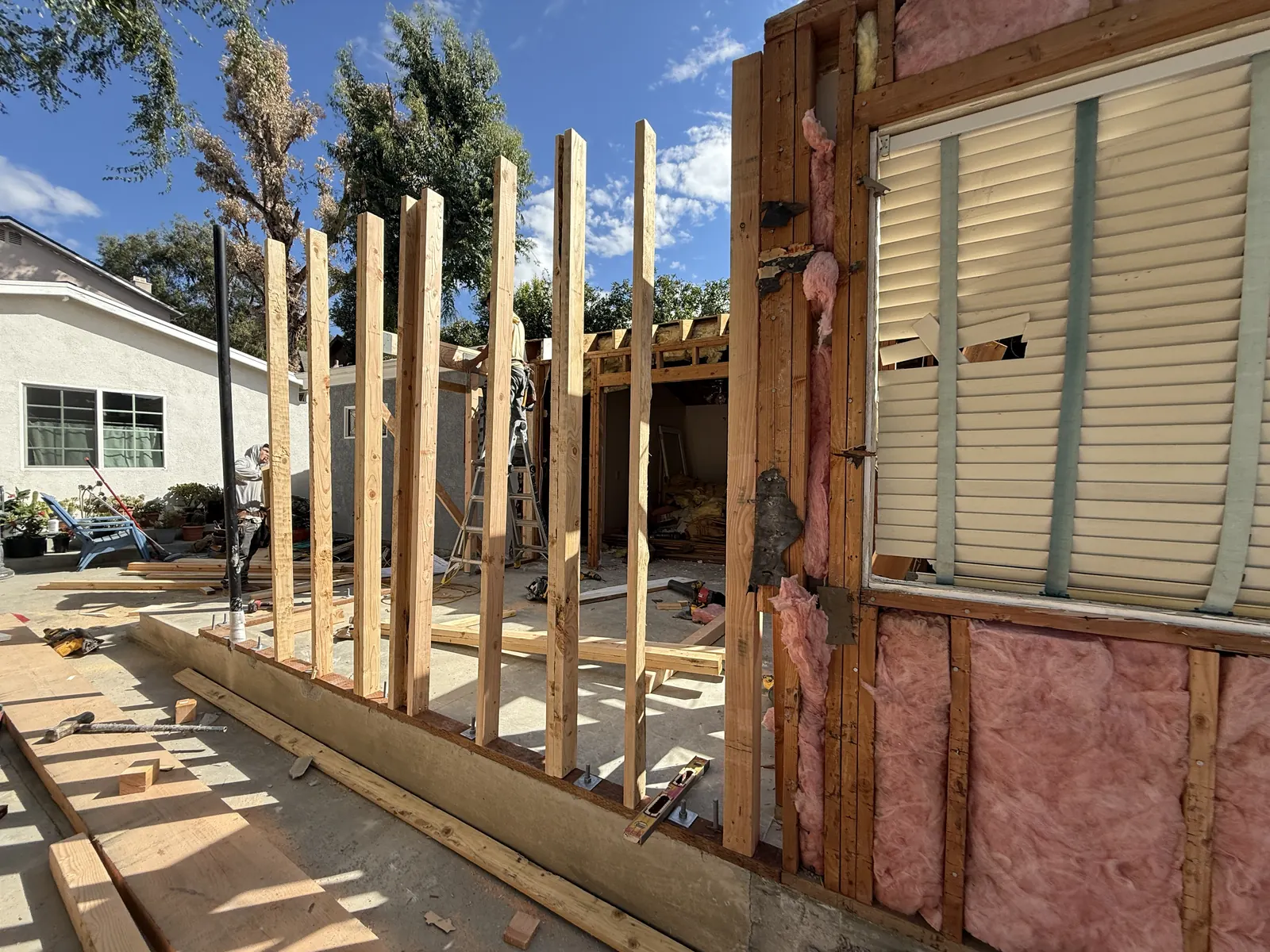 Fresh wall studs rise from an anchor-bolted sill plate along the rear expansion footprint at PMK's addition-and-remodel project in La Crescenta.