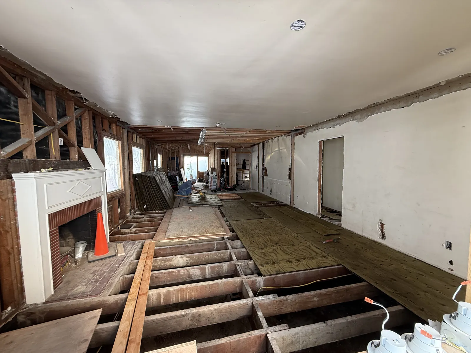 Exposed floor joists receive new plywood subfloor sheets across the main living space during structural work on PMK's La Crescenta addition-and-remodel project.