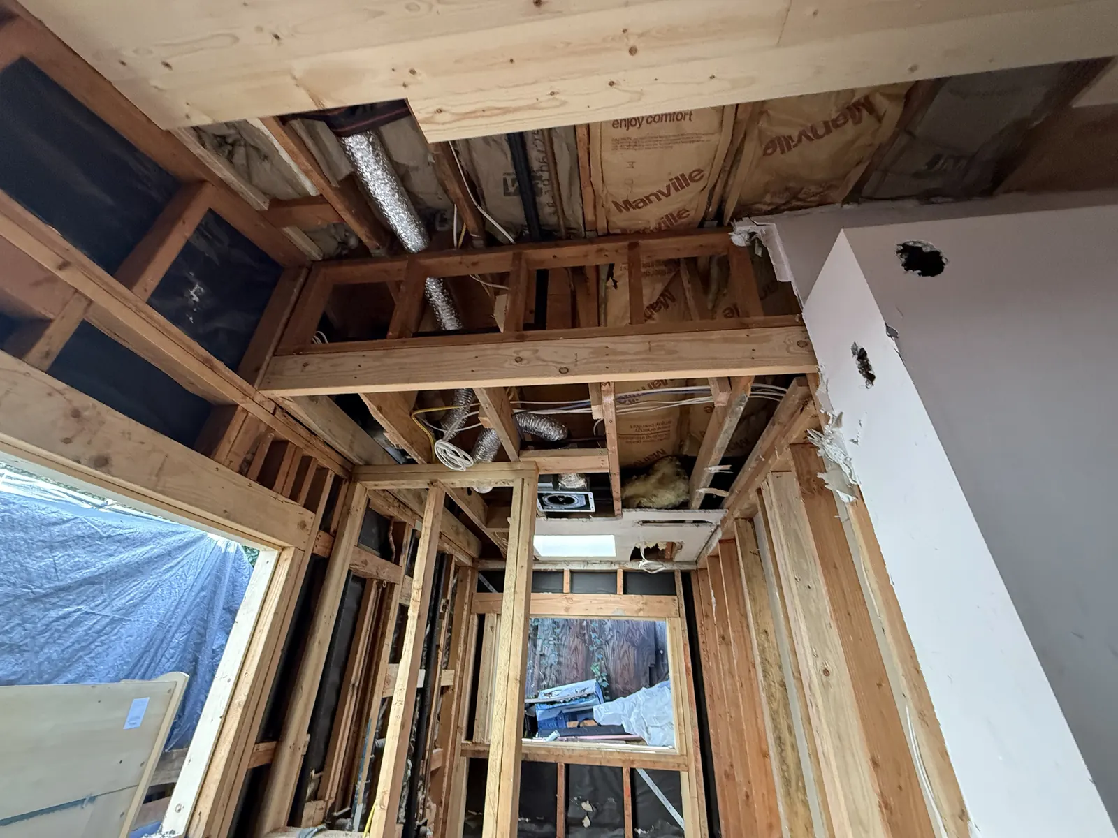 Flexible HVAC ducts and electrical runs thread through the open ceiling framing during rough-in at PMK's La Crescenta addition-and-remodel project.