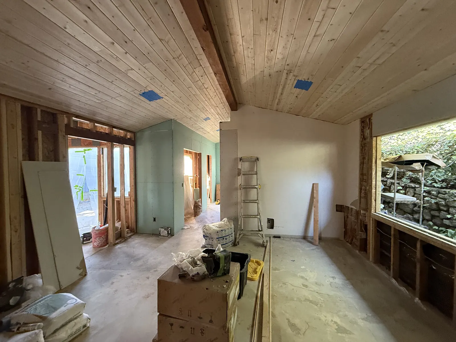 A new tongue-and-groove wood ceiling spans the room as moisture-resistant drywall goes up on the walls of PMK's addition-and-remodel project in La Crescenta.