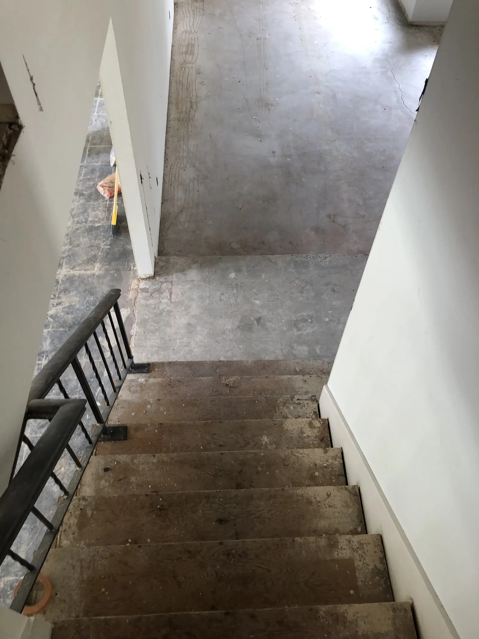 Staircase with carpet removed down to bare plywood treads during the PMK home-remodel project on Glenwood Avenue in Fullerton.