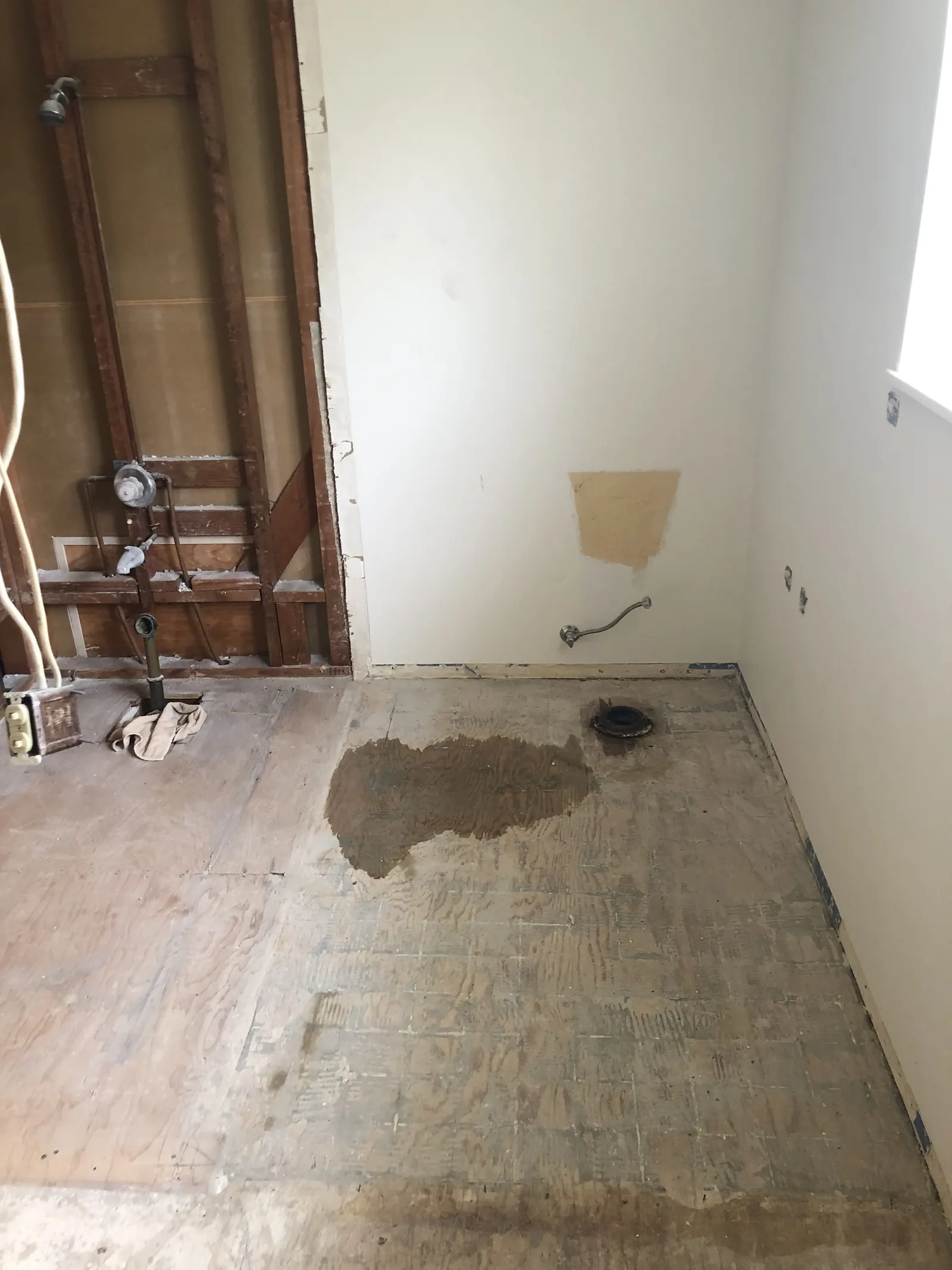 Gutted master bathroom with subfloor exposed and shower plumbing wall opened during the PMK home remodel on Glenwood Avenue in Fullerton.