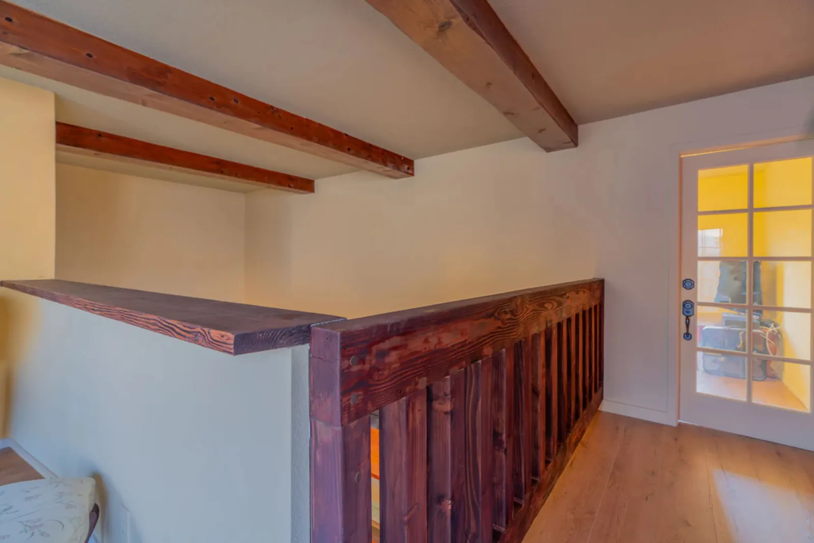 Refinished wood loft railing and stair detail at the remodeled Harvard, Los Angeles home