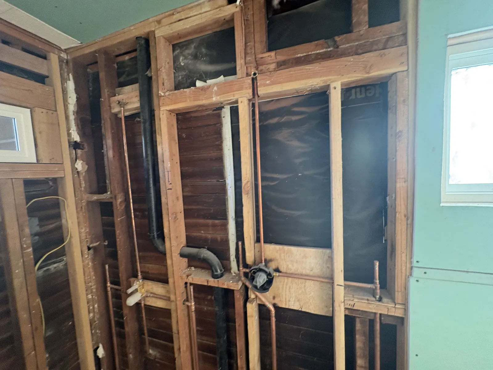 New copper supply lines and drain plumbing roughed into open wall framing at PMK's remodel project on Hobart Blvd in Los Angeles.