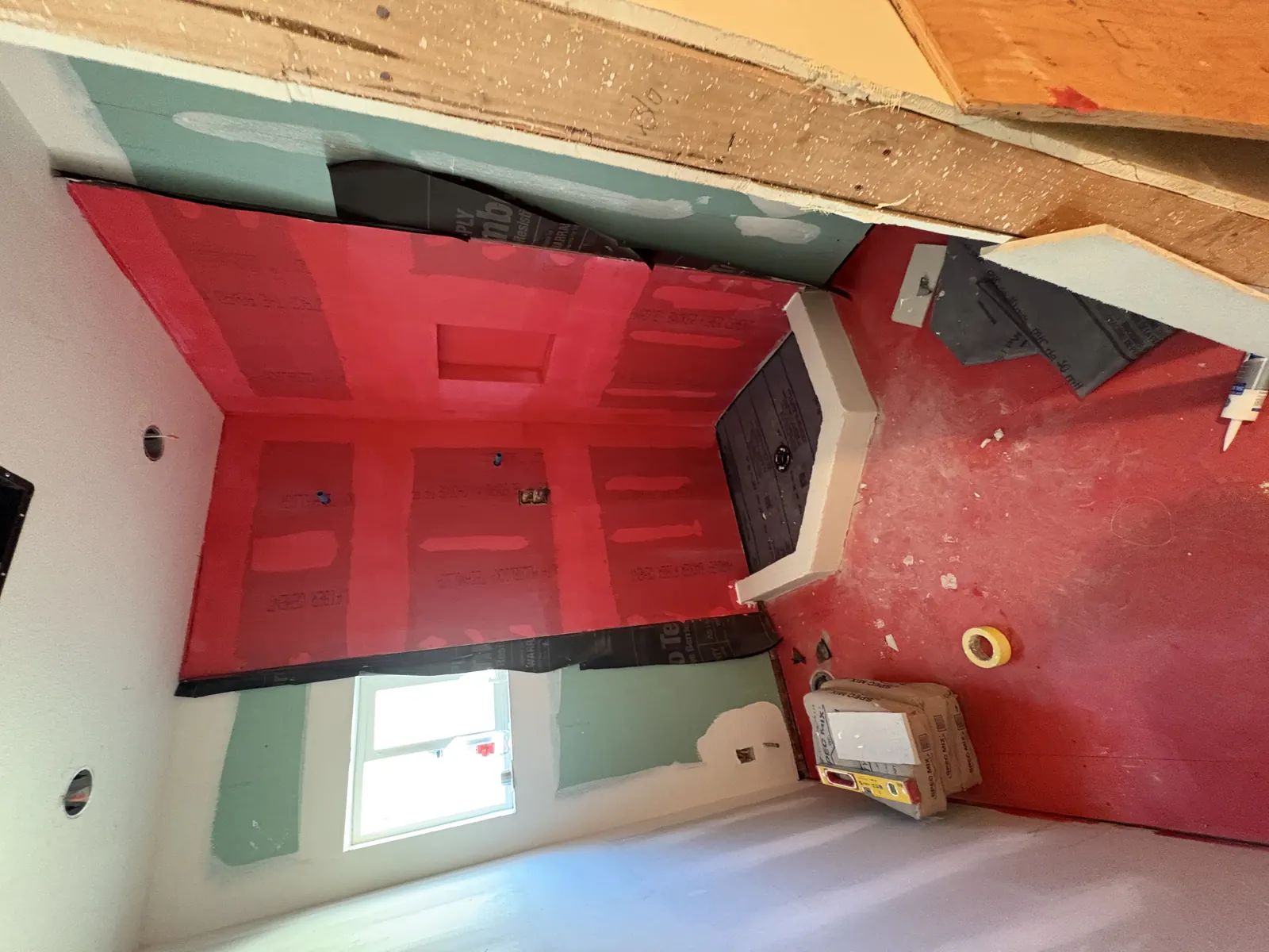 Waterproofing membrane coats the new shower walls and pan during bathroom rough-in at PMK's Hobart Blvd remodel in Los Angeles.