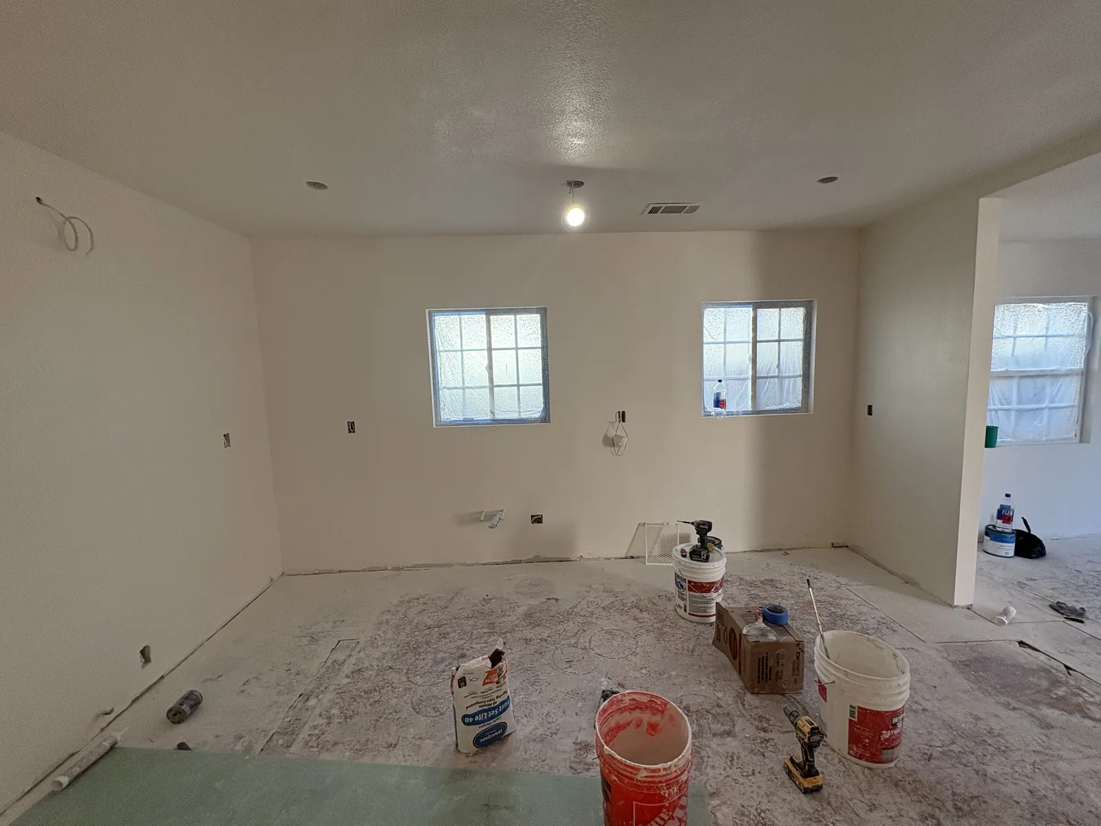 The new open-concept living area with drywall taped and primed, awaiting final finishes, at PMK's remodel on Hobart Blvd in Los Angeles.