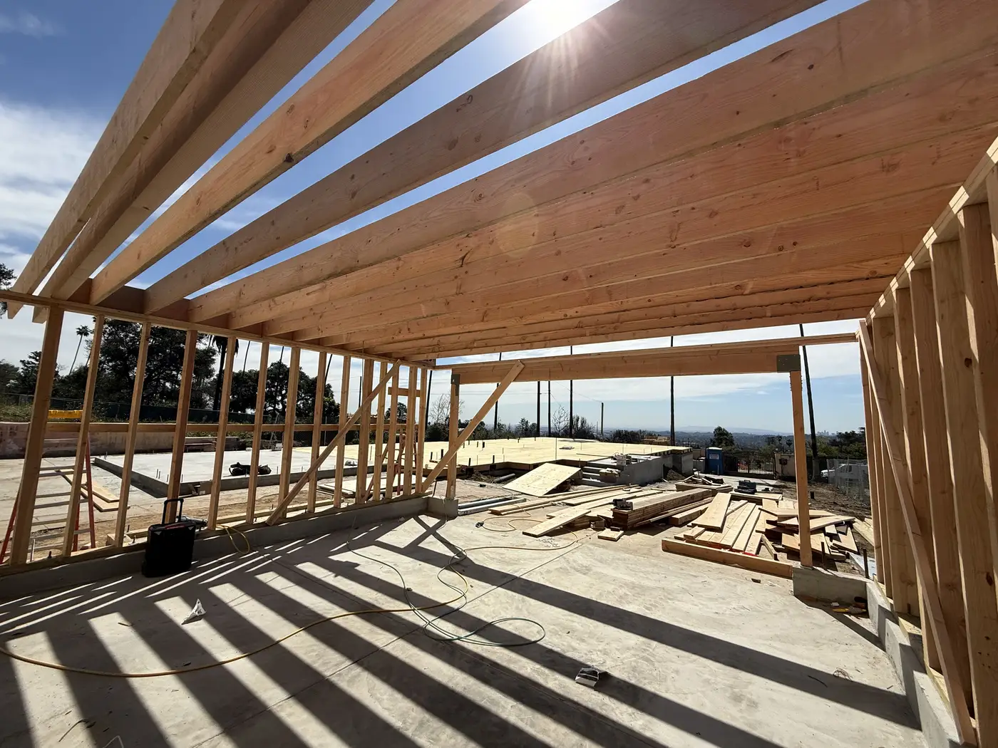 First framed walls and exposed roof beams over the ADU deck at PMK Development's Altadena rebuild.