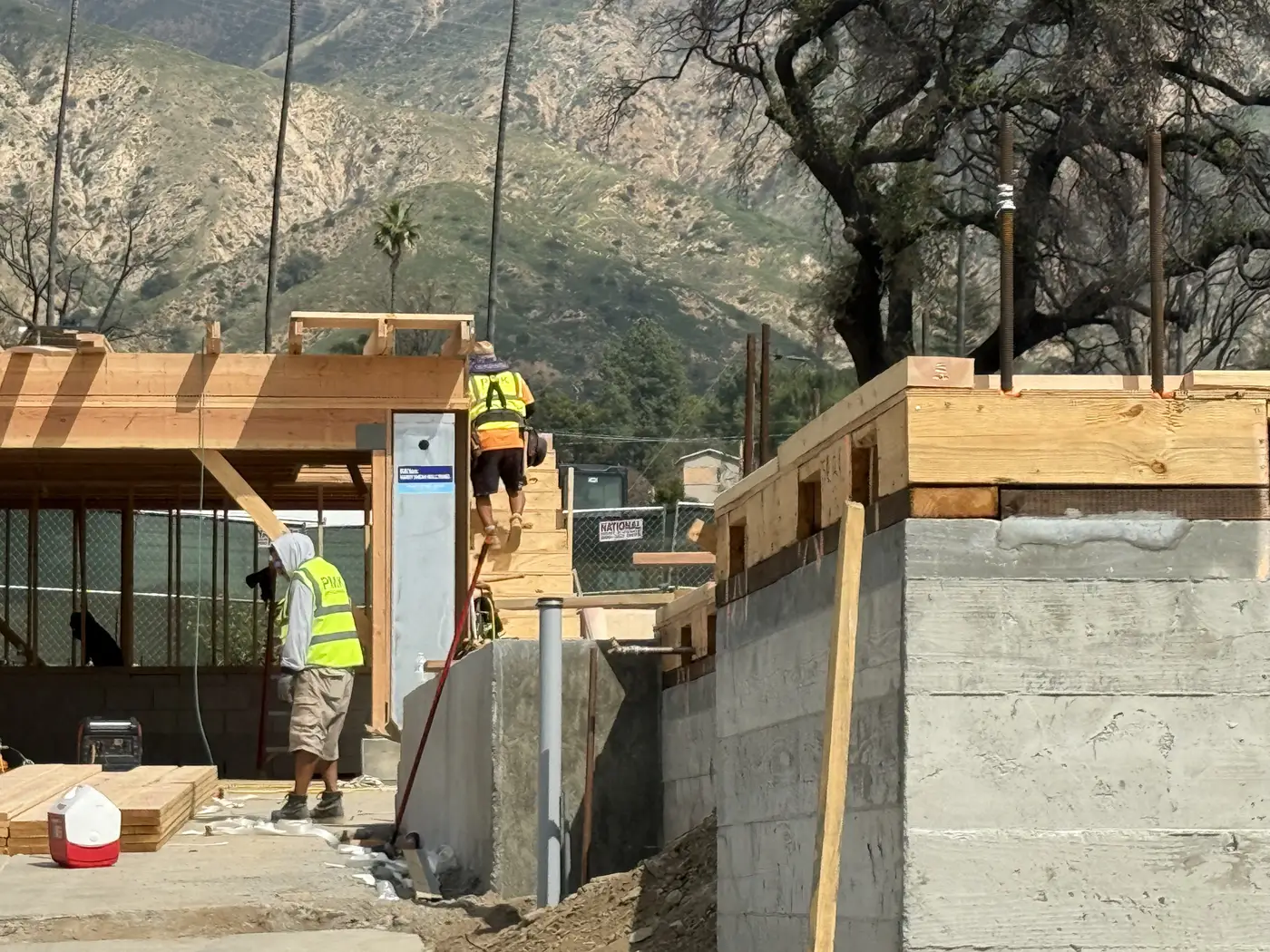 PMK crew members plating and laying out framing beside the concrete retaining wall in Altadena.