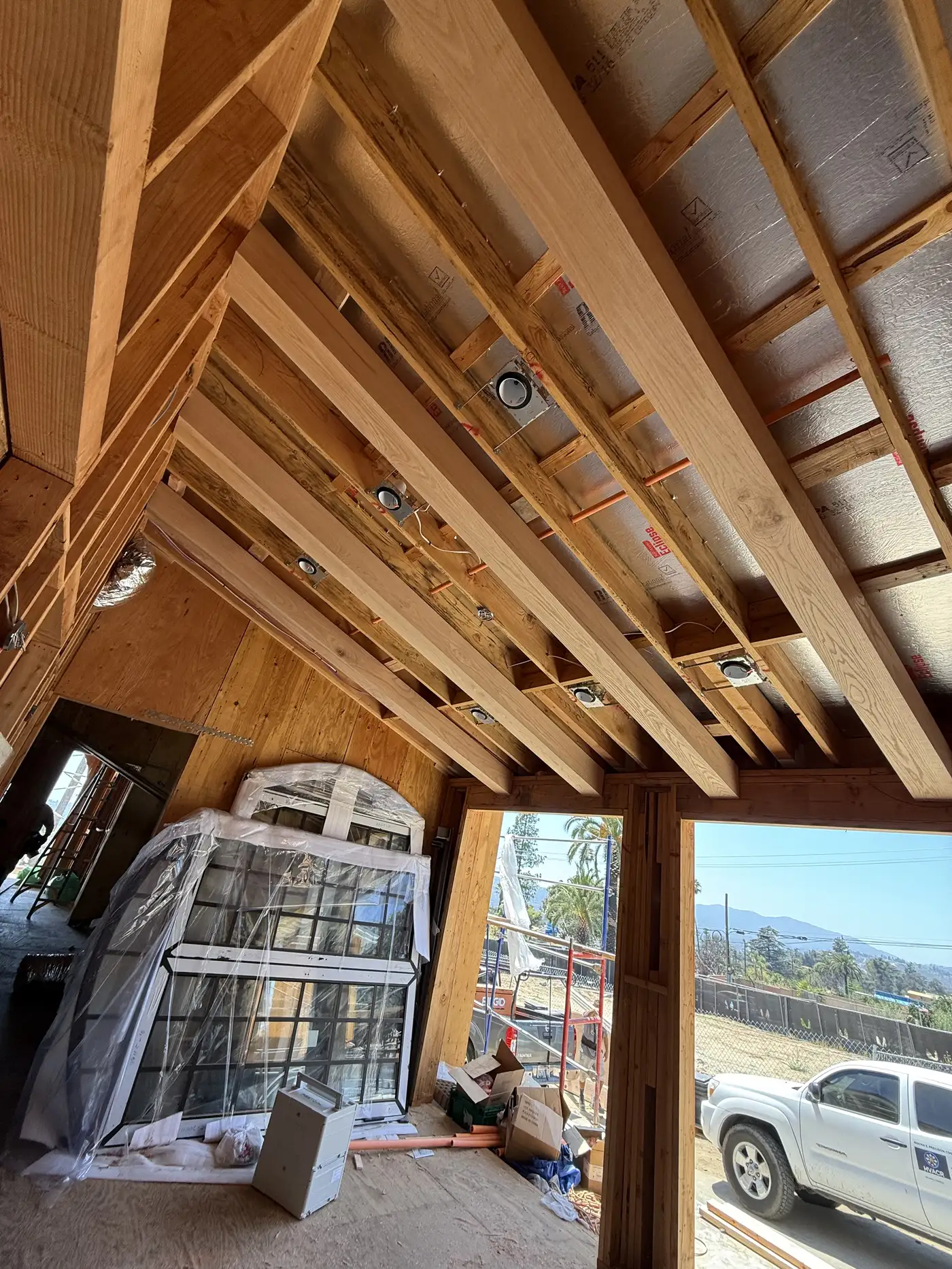 Exposed interior ceiling beams with recessed lighting cans at PMK Development's Altadena rebuild.