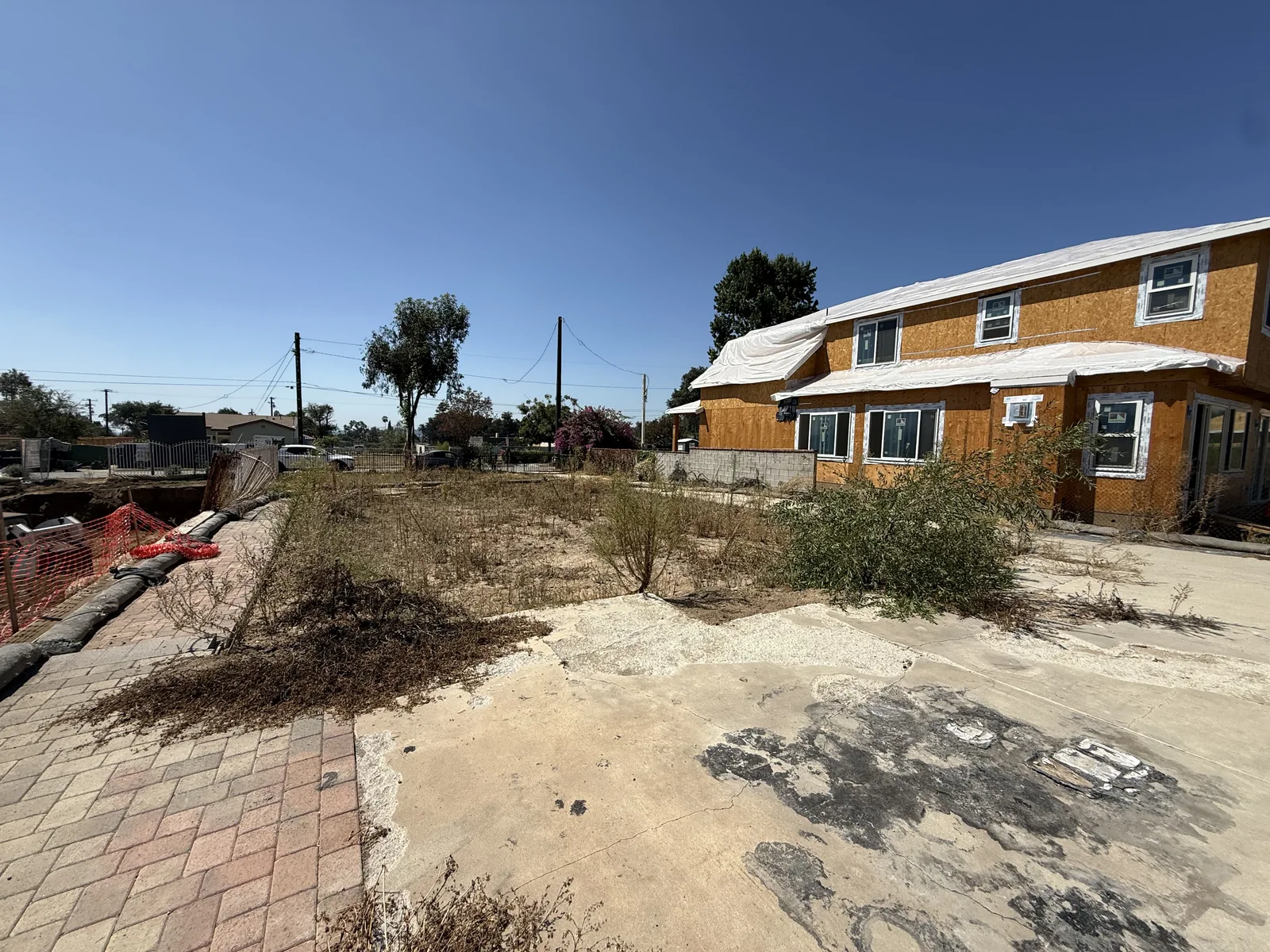 View from inside the Mendocino lot toward the street, showing existing paving and neighboring construction