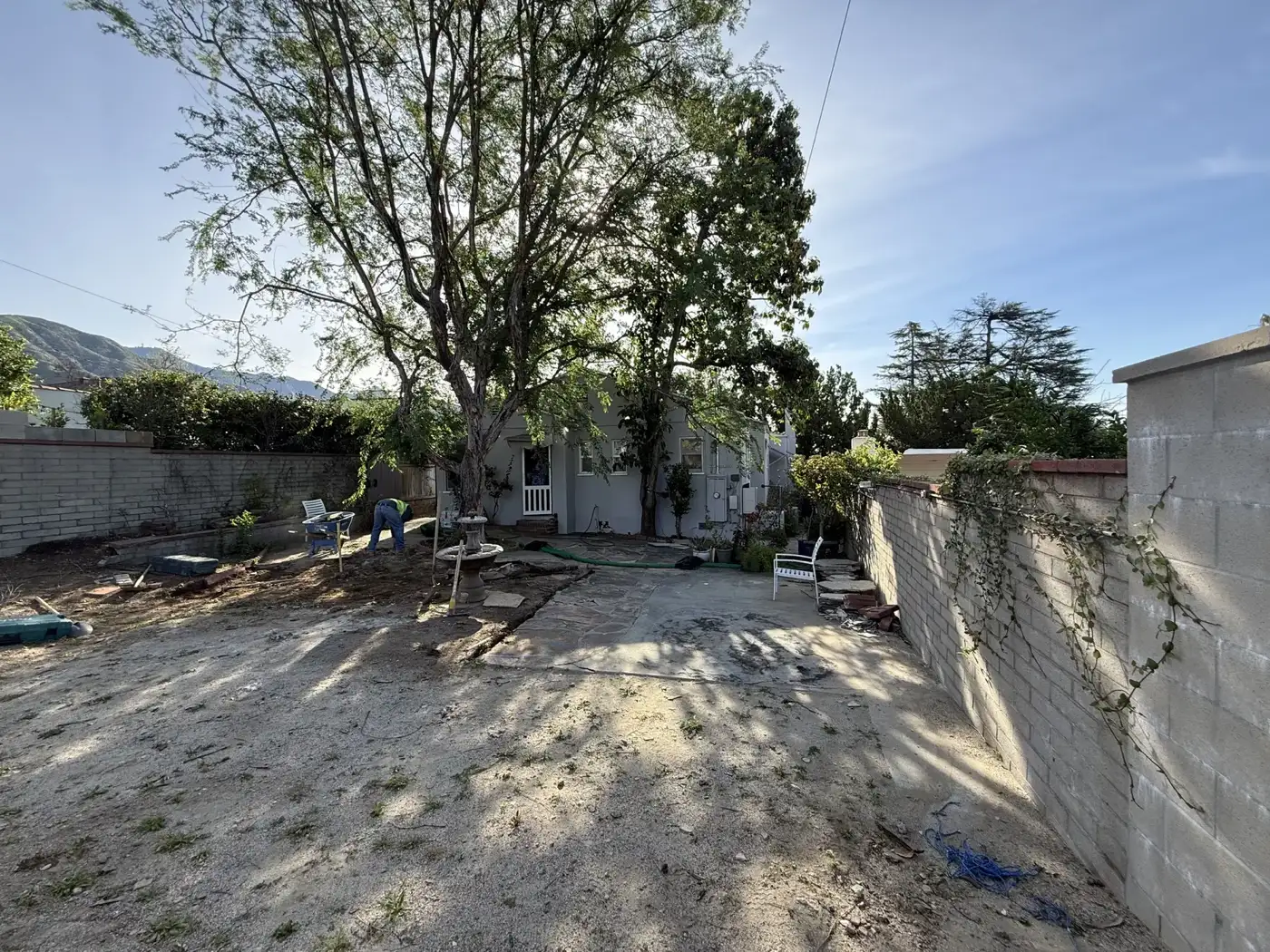 Cleared yard with demolition underway behind the block wall at PMK Development's Mt. Curve Avenue project in Altadena.