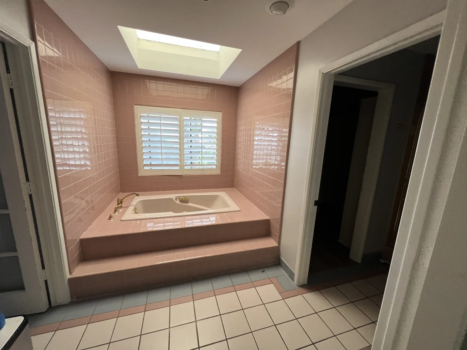 Dated pink-tiled primary bathroom with a built-in tub before PMK Development's remodel in Claremont, California