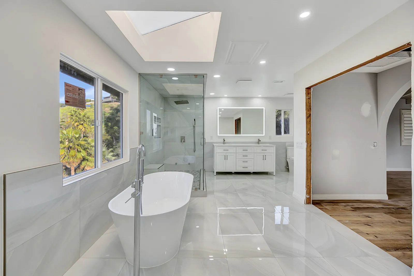 Finished modern primary bathroom with a freestanding tub and white marble from a PMK Development remodel in Claremont, California