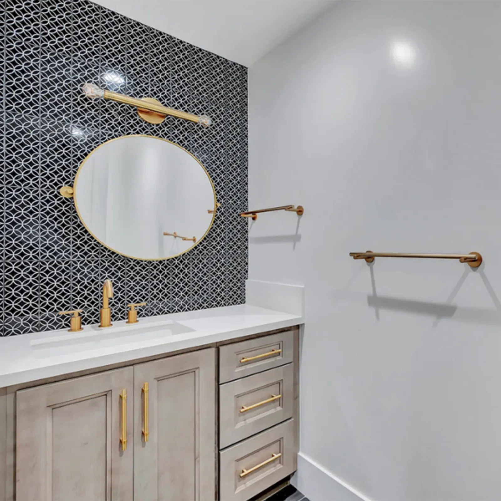 Finished bathroom with patterned tile, a round mirror, and brass fixtures from a PMK Development project in La Cañada Flintridge
