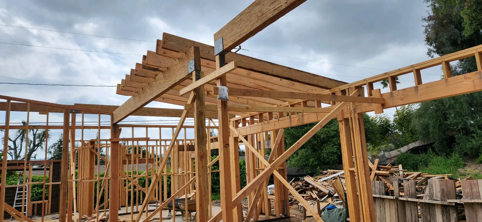 New exposed wood beams and rafters going up over the addition's stud walls at PMK's addition-and-renovation project in La Cañada Flintridge.
