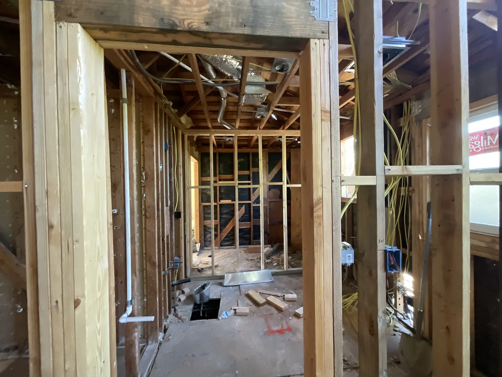 Framed bathroom walls with copper supply lines, drain openings, and electrical wiring run through the studs during rough-in at PMK's addition-and-renovation project in La Cañada Flintridge.
